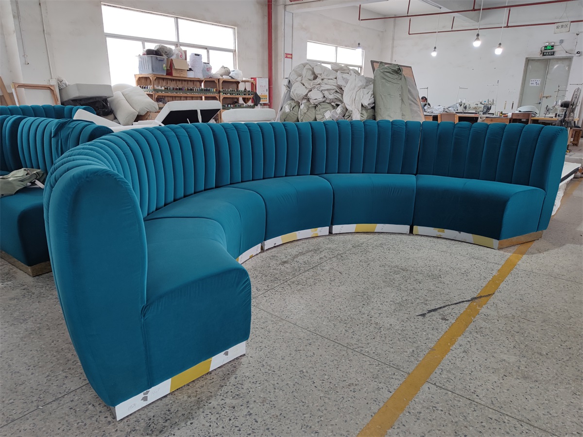 Curved velvet hotel lobby banquette with vertical channel tufting