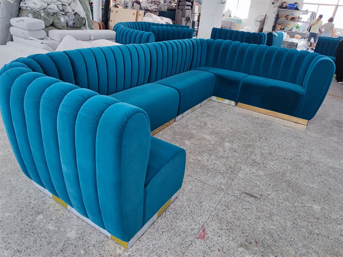 Modern U-shaped sofa with gold base and plush velvet upholstery for upscale interiors