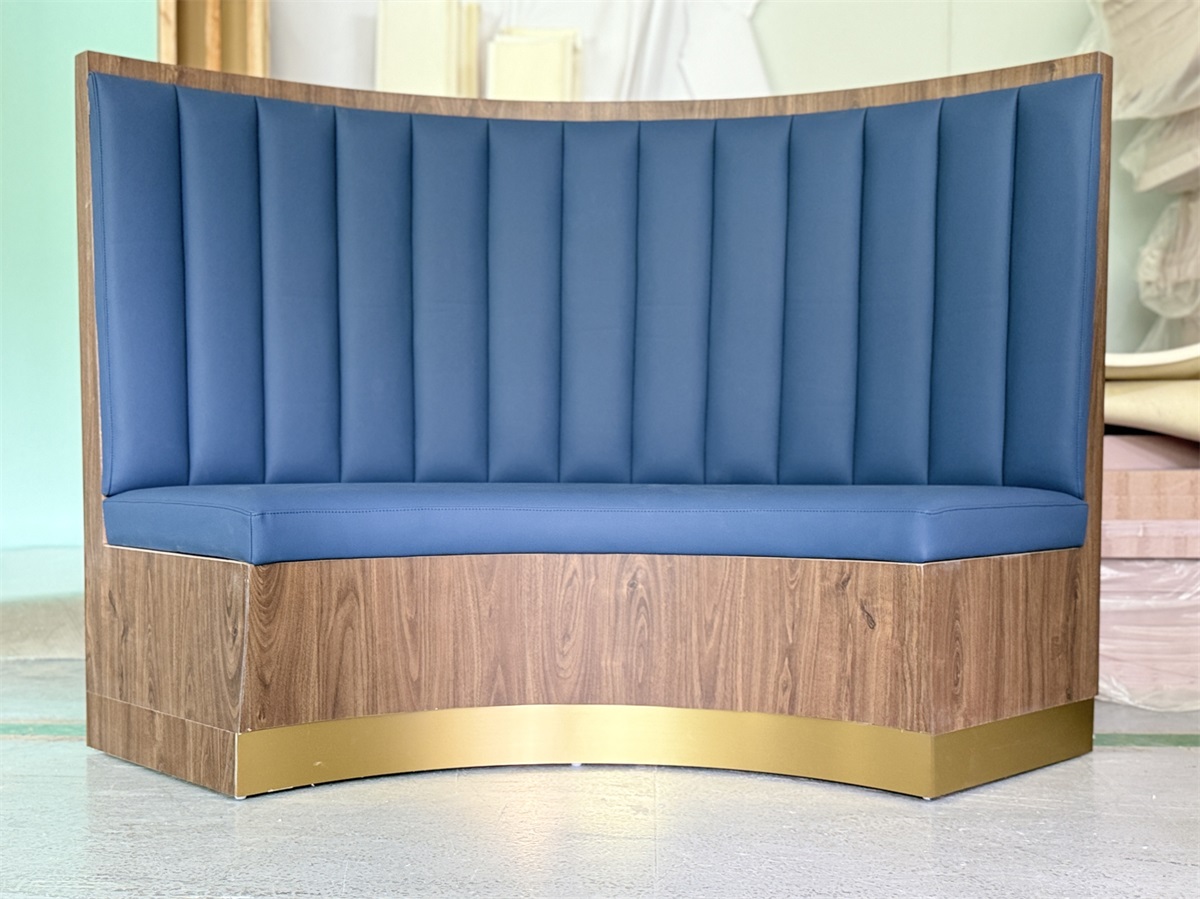 Curved blue upholstered restaurant booth with wood veneer and gold base