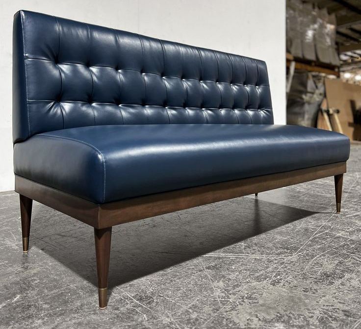Blue leather restaurant booth with tufted back and wood legs