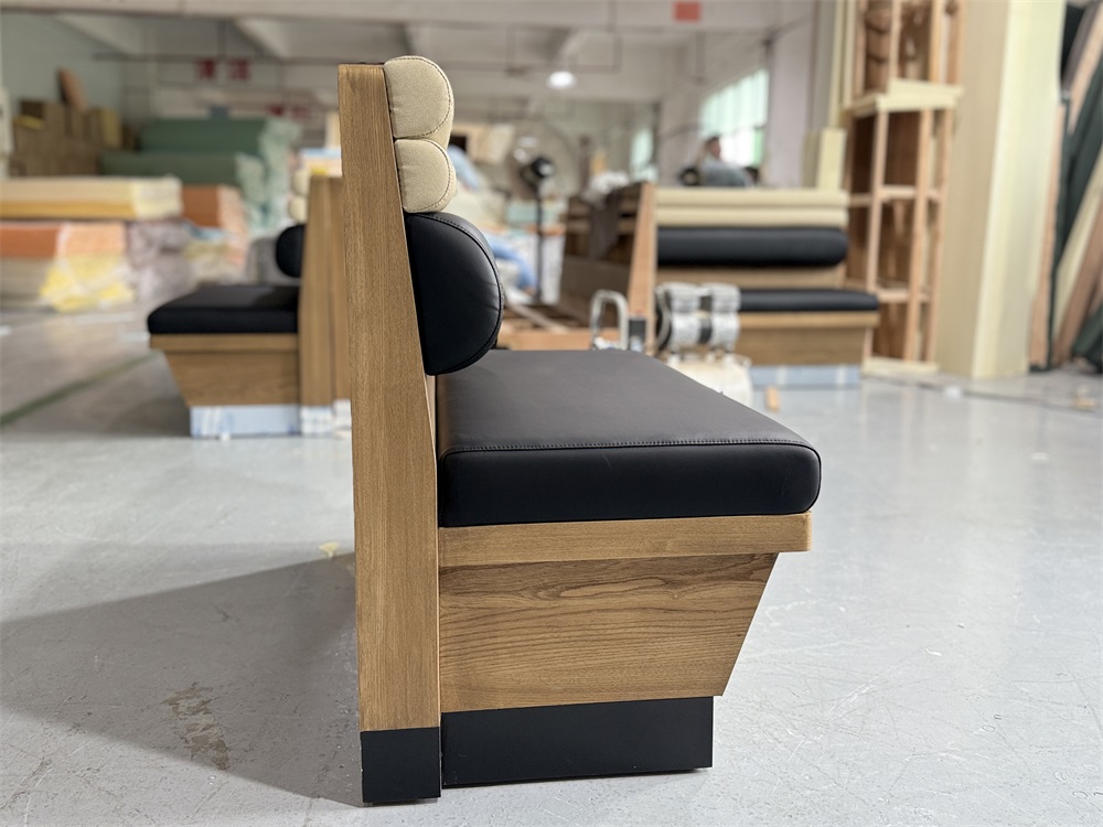 Side view of modern restaurant booth with wood base and cushione