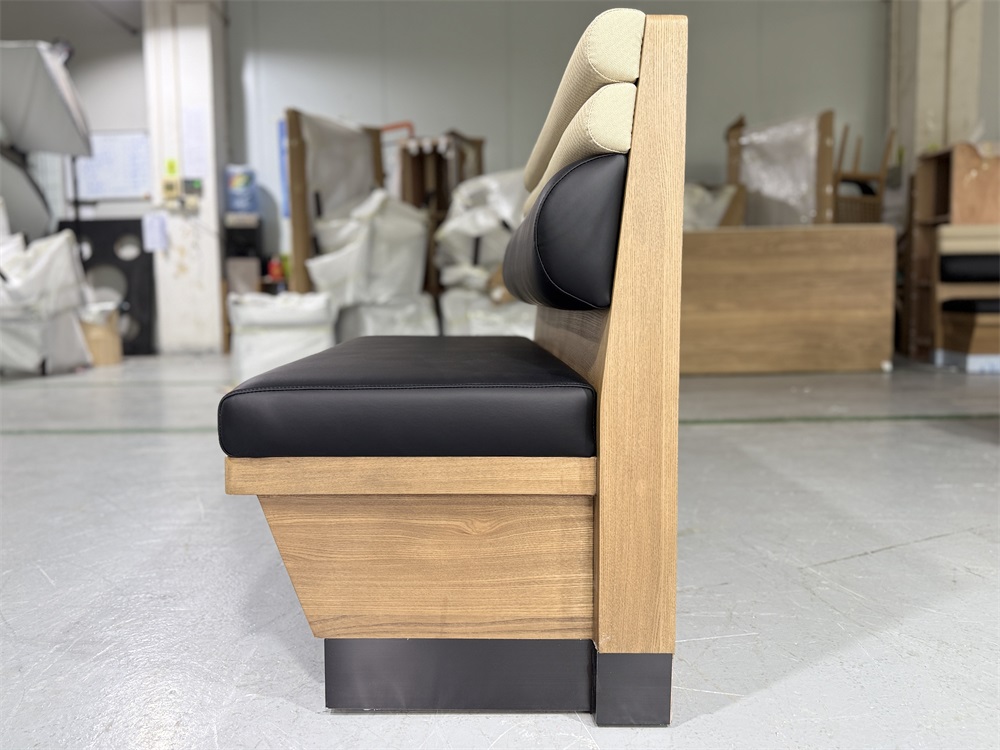 Profile view of black and beige commercial booth seat with sleek wood finish